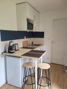 a kitchen with two stools and a counter with a sink at L'Home Had_oro in Nantes