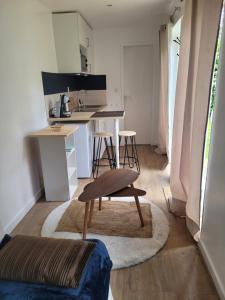 a kitchen with a table and a chair in a room at L'Home Had_oro in Nantes
