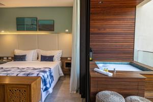 Cette chambre comprend un lit et une baignoire. dans l'établissement Wyndham Ilhabela Casa Di Sirena, à Ilhabela