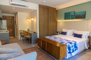 Wyndham Ilhabela Casa Di Sirena في إلهابيلا: غرفة نوم بسرير كبير وغرفة معيشة
