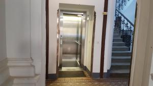 a hallway with a metal door and stairs at Gorgeous Viennese Apartment 10 min to City Center in Vienna