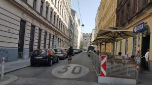 uma pessoa a andar de bicicleta numa rua da cidade em Gorgeous Viennese Apartment 10 min to City Center em Viena