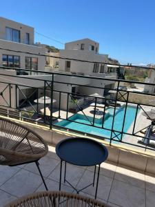 a balcony with chairs and a swimming pool on a building at Melina's Apartments in Nea Kydonia