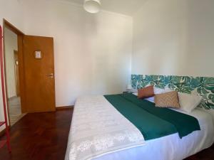 Schlafzimmer mit einem großen Bett mit grüner und weißer Bettwäsche in der Unterkunft Anchor House in Albufeira