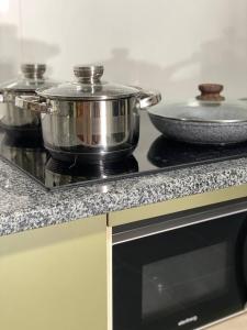 two pots and pans sitting on top of a stove at TREND HOUSE Apartments & Hostel in Vinnytsya