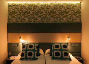 a bed with two pillows and a large painting above it at Hotel Apartamento Bajamar in Las Palmas de Gran Canaria