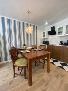 ein Esszimmer mit einem Holztisch und Stühlen in der Unterkunft Tabago Studio 19 in Kędzierzyn-Koźle