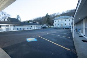 an empty parking lot with a building in the background at Watkins Motel in Watkins Glen