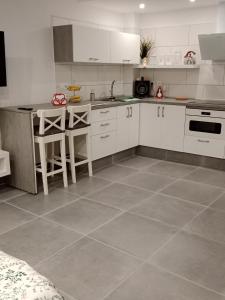 eine Küche mit weißen Schränken und einem Fliesenboden in der Unterkunft Mini Casa cerca del Mar in Punta del Hidalgo