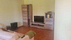a living room with a couch and a flat screen tv at Las Brisas - planta baja independiente in Marianes
