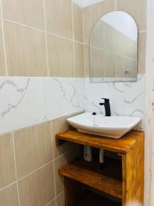 y baño con lavabo y espejo. en Casa Cinza, en Ponta do Ouro