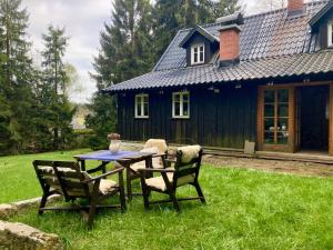 Una mesa y sillas frente a una casa en Chata Hrabětice, en Jablonec nad Nisou