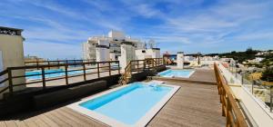 un balcón con 2 piscinas en un edificio en 3H Terrace - Casas & Papéis, en Armação de Pêra