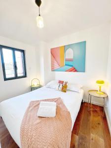 een slaapkamer met een groot wit bed en 2 ramen bij BOHO * hypercentre * St Georges in Toulouse