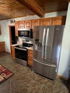 a kitchen with stainless steel appliances and wooden cabinets at The Clear Lake Retreat in Forest Lake +12 photos