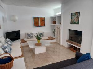 een woonkamer met witte meubels en een open haard bij Ático en Estepona, Malaga in Estepona