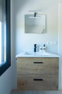a bathroom with a white sink and a mirror at Villa 25 in Cabra