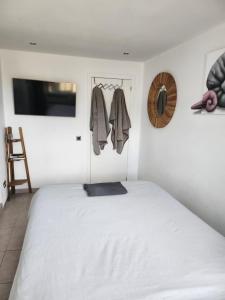 1 dormitorio con 1 cama blanca y TV en Casa Salvia Bed and Breakfast, en Icod de los Vinos