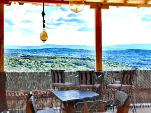 a table and chairs on a porch with a view at Holiday Complex ARBANASHKI STYLE-Panoramic View, Jacuzzi, Sauna, Children's park- ALL SPA SERVICES are INCLUDED in the price in Veliko Tŭrnovo