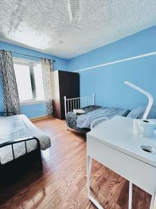 Habitación con 2 camas y escritorio blanco. en Kensington Market House, en Toronto