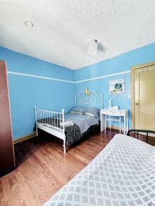 1 dormitorio con paredes azules, 1 cama y 1 mesa en Kensington Market House, en Toronto
