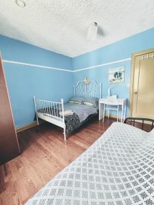 1 dormitorio con paredes azules, 1 cama y 1 mesa en Kensington Market House, en Toronto
