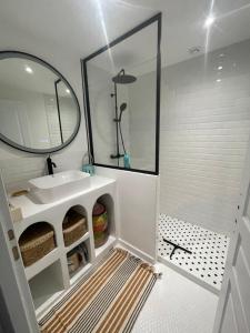 a bathroom with a sink and a mirror at Maison de village in Caux +17 photos