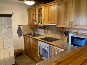a kitchen with wooden cabinets and a stove top oven at Chata Hrabětice in Jablonec nad Nisou