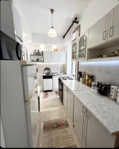 Una cocina con gabinetes blancos y una encimera blanca. en Bella Vista Sarajevo, en Sarajevo