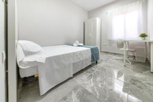 a white hospital room with a bed and a table at Apartamento Duque Nájera (playa La Caleta, Cádiz) in Cádiz