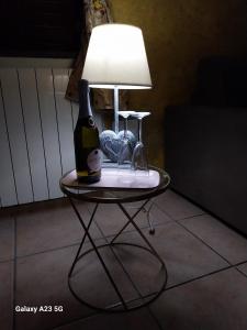 een tafel met een fles wijn en een lamp bij Luxury bnb Le Rocce in Villasmundo