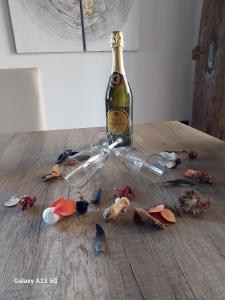 een fles wijn bovenop een houten tafel bij Luxury bnb Le Rocce in Villasmundo