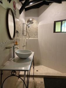 y baño con lavabo y espejo. en Old Bells Hostel- Villa El Campanario, en Santa Ana