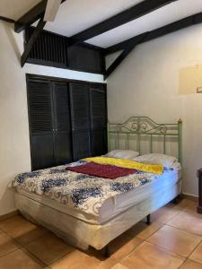 1 dormitorio con 1 cama con cabecero de madera en Old Bells Hostel- Villa El Campanario, en Santa Ana