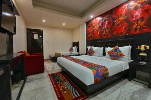 1 dormitorio con 1 cama y una gran pintura en la pared en Hotel Noida International - opposite Mercedes Showroom Noida Sector 11 en Nueva Delhi