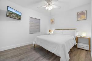una camera bianca con letto e ventilatore a soffitto di Comfortable house for Your Enjoyment in Miami a Miami