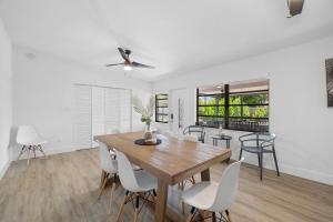 una sala da pranzo con tavolo in legno e sedie bianche di Comfortable house for Your Enjoyment in Miami a Miami