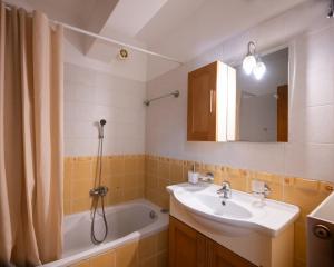 y baño con lavabo y bañera. en Marilia house en Lefkada