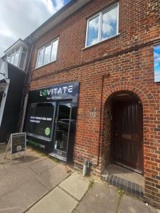 a brick building with the entrance to a store at St Albans City Stays - Near Luton Airport - St Albans Abbey & City Train station - Close to London- Harry Potter World - The Odyssey Cinema - Abbey Cathedral- Contractors I Business I Leisure- sleeps upto 6 people in Saint Albans