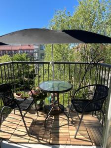 een tafel en stoelen op een terras met een paraplu bij Garden City Apartment, Helsinki - Vantaa Airport in Vantaa