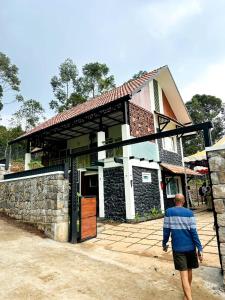 a man walking in front of a building at Black stone in Chinnakanal