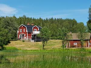 a large red house sitting on top of a field at Landhaus Lönneberga in Lönneberga