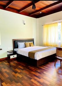 a bedroom with a large bed and a wooden floor at Black stone in Chinnakanal +10 photos