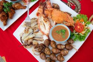 a plate of food with seafood and dipping sauce at Modtanoi Paradise Homestay in Ban Bu Lu