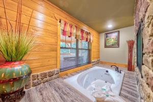 a bathroom with a tub in a room with a window at A Breath of Fresh Air in Gatlinburg +56 photos