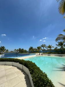 a swimming pool with blue water and palm trees at HerSpace Staycation in San Fernando