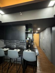 a kitchen with two sinks and white chairs at HerSpace Staycation in San Fernando