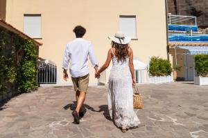 un hombre y una mujer caminando por una calle tomados de la mano en Marina Grande Residence & SPA, en Sorrento