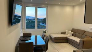 a living room with a couch and a table and a window at Apartments Villa Prima in Privlaka