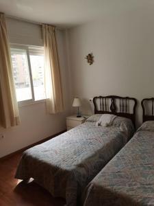 a bedroom with two beds and a window at Apartamento junto a puerto Fuengirola in Fuengirola